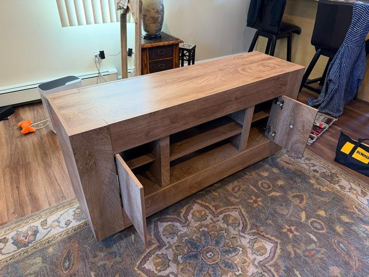 An oak TV console cabinet with open shelves, assembled by Pamphile Assembly